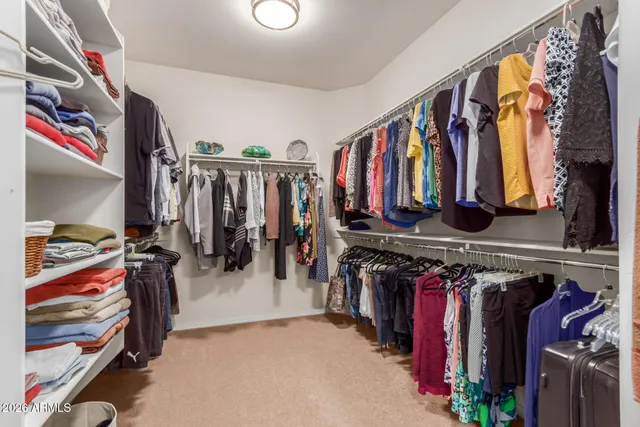 a view of walk in closet with clothes