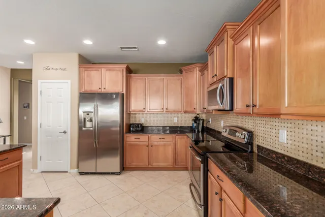 a kitchen with stainless steel appliances granite countertop a stove a refrigerator and a sink