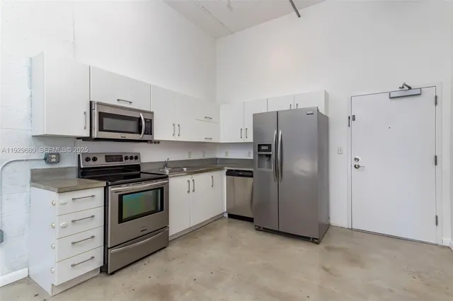 a kitchen with stainless steel appliances granite countertop a refrigerator stove and sink
