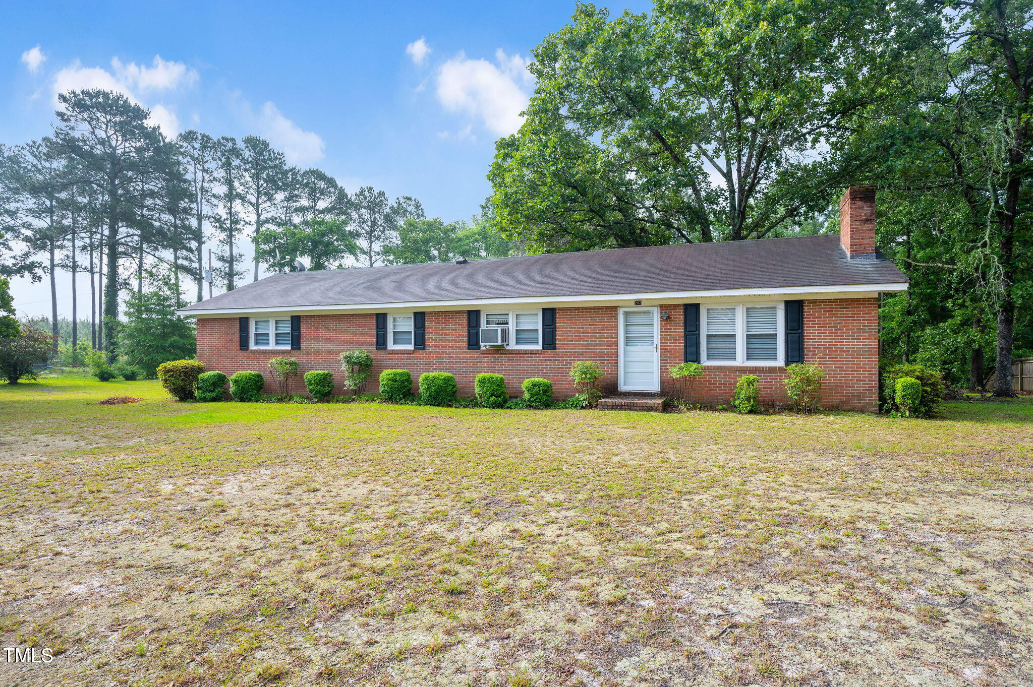 a front view of a house with a yard and trees