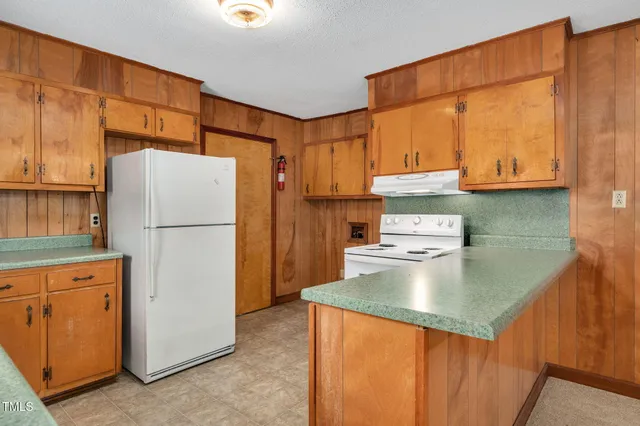 a kitchen with a refrigerator a stove a sink dishwasher and cabinets with wooden floor