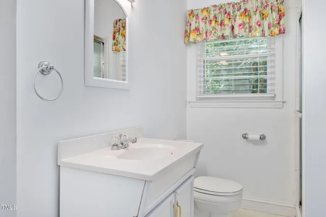 a bathroom with a sink a toilet and a window