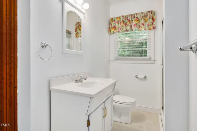 a bathroom with a toilet a sink and a mirror