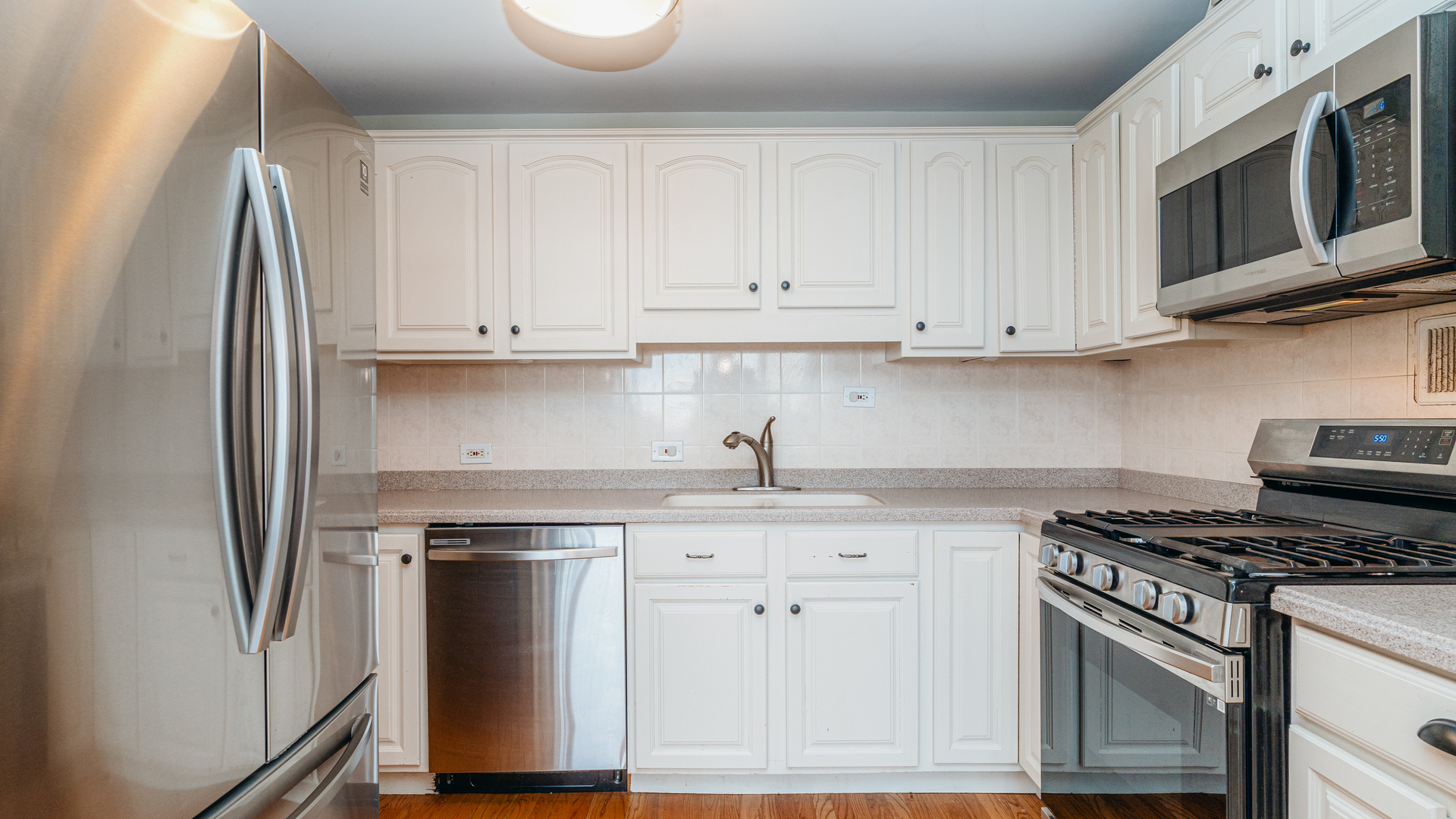 400 East Randolph Street, Unit 3915 Chicago, IL 60601 - Photo 4 of 16 a kitchen with granite countertop white cabinets and stainless steel appliances