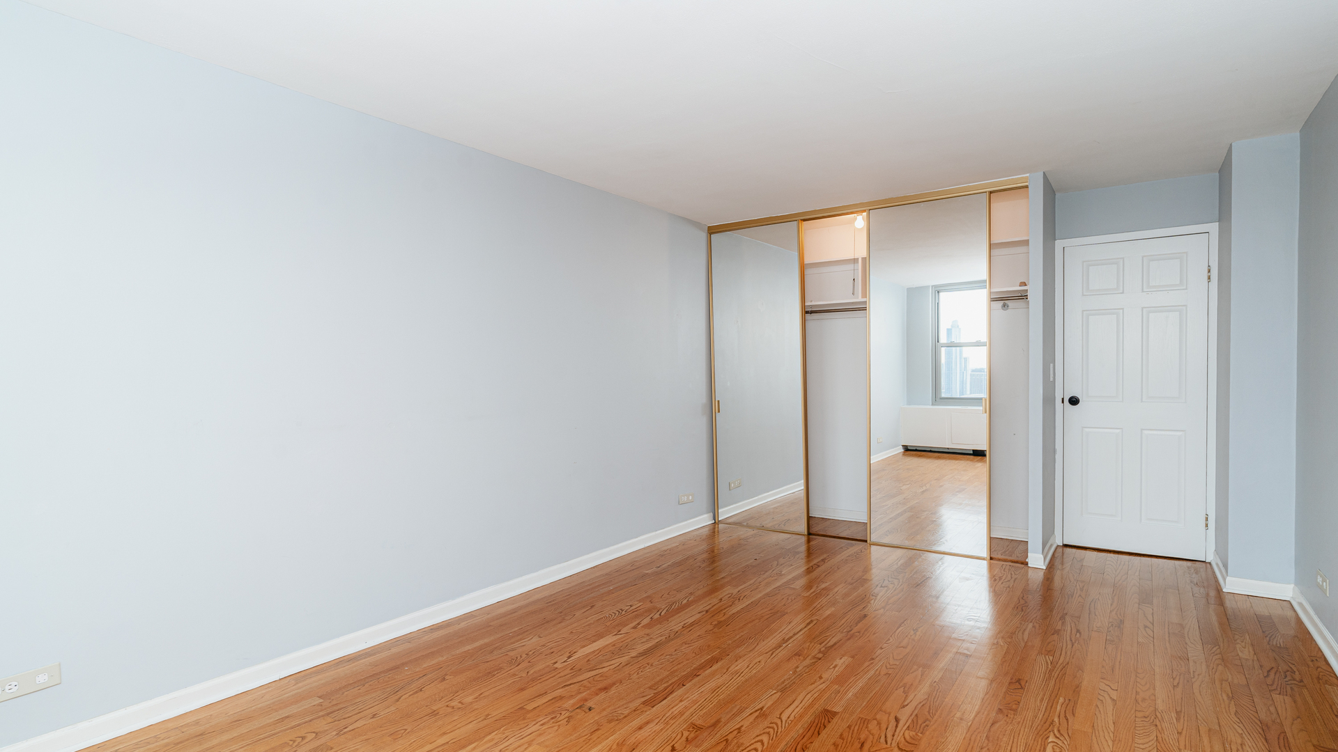 400 East Randolph Street, Unit 3915 Chicago, IL 60601 - Photo 9 of 16 a big room with wooden floor and bathroom view