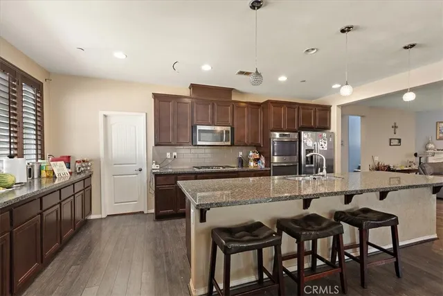 a large kitchen with granite countertop lots of counter space and refrigerator