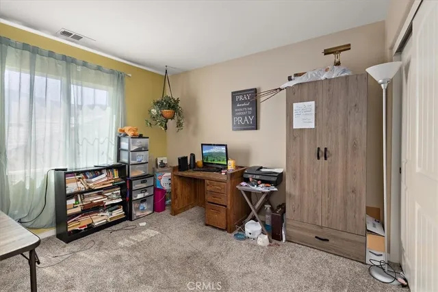 a view of a workspace with furniture and a window