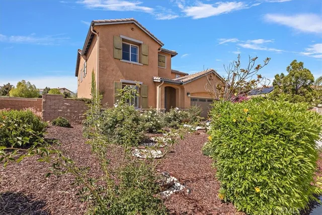 a view of a house with a yard and garden