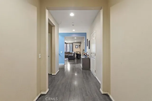 a view of a hallway with wooden floor a fireplace and livingroom