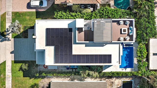 an aerial view of a house with a yard and potted plants