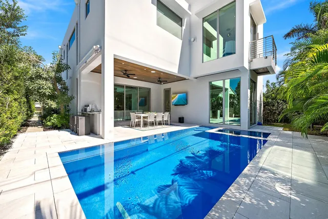 a view of a house with swimming pool and sitting area