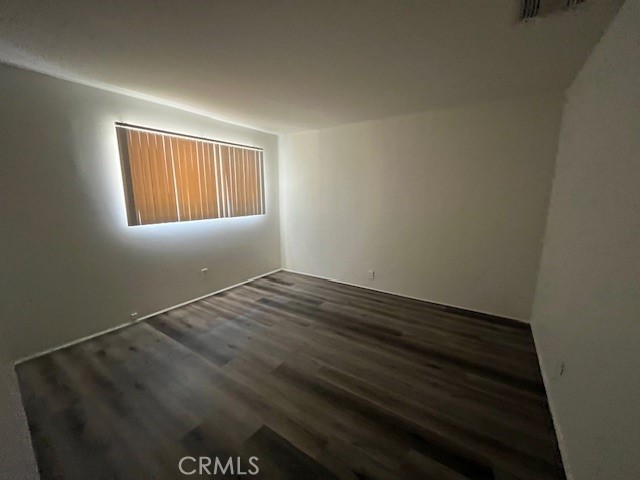 73740 Santa Rosa Way, Unit C Palm Desert, CA 92260 - Photo 15 of 18 an empty room with wooden floor and windows