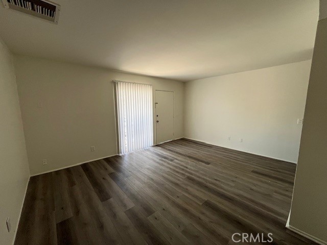 73740 Santa Rosa Way, Unit C Palm Desert, CA 92260 - Photo 10 of 18 an empty room with wooden floor and windows