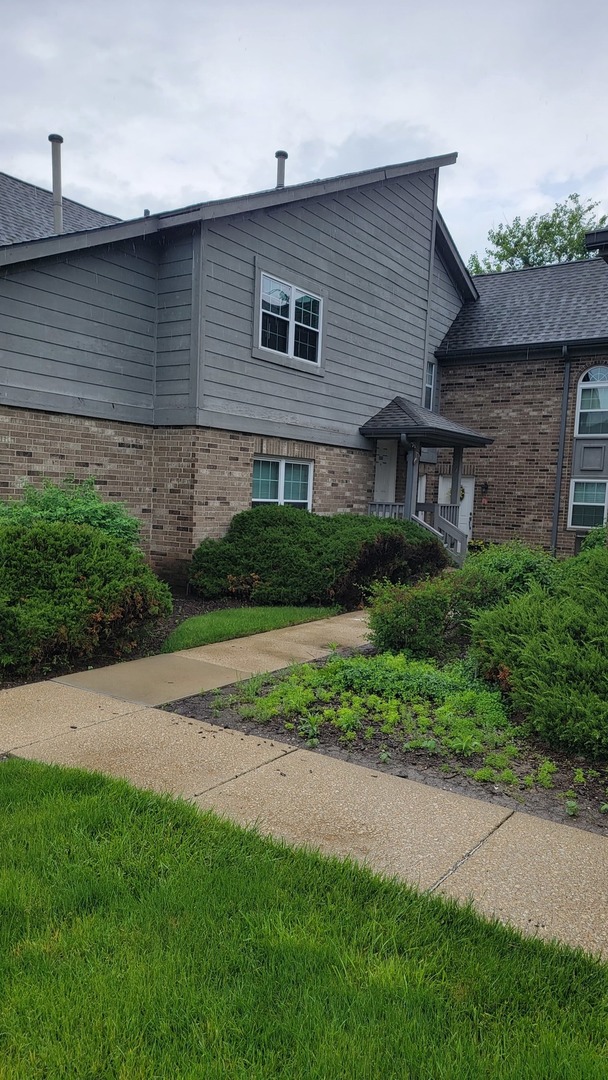 19 Foxcroft Road, Unit 131 Naperville, IL 60565 - Photo 1 of 22 a brick house with a yard plants and big trees