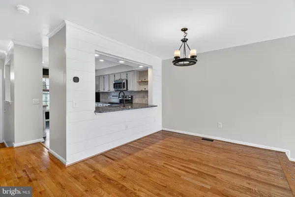 a view of a room with wooden floor and white walls