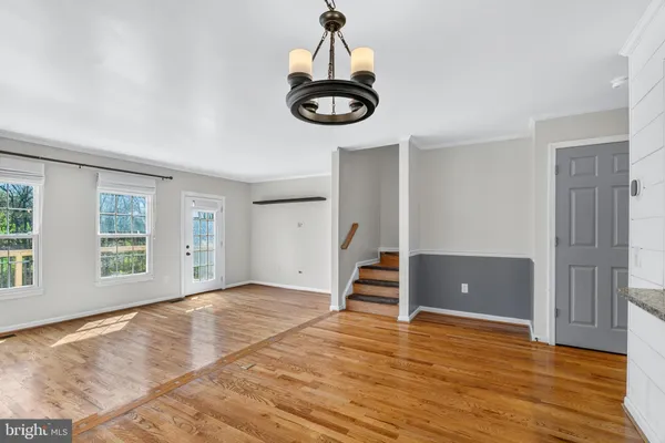 a view of empty room with wooden floor and window