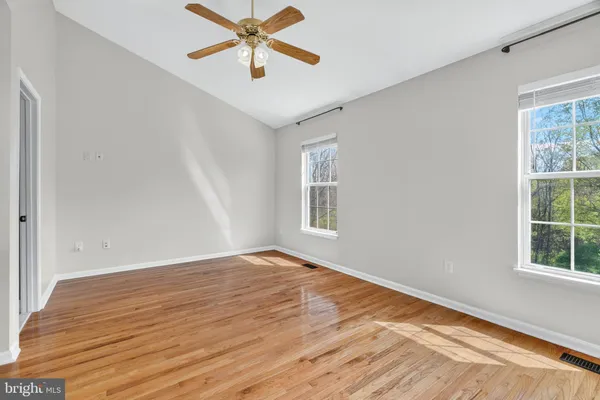 an empty room with windows and fan
