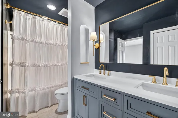 a bathroom with a double vanity sink toilet and a mirror