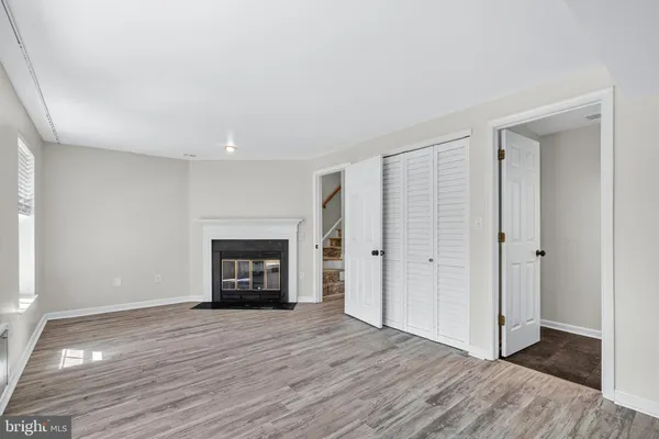 a view of an empty room with a window and fireplace