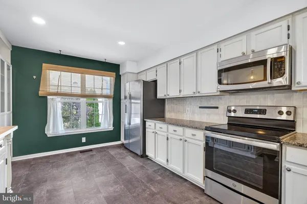a kitchen with stainless steel appliances granite countertop a stove microwave and sink