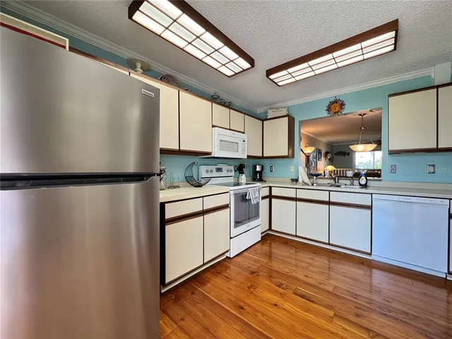 a dining room with furniture a chandelier and wooden floor