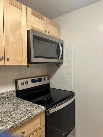 a stove top oven sitting inside of a kitchen