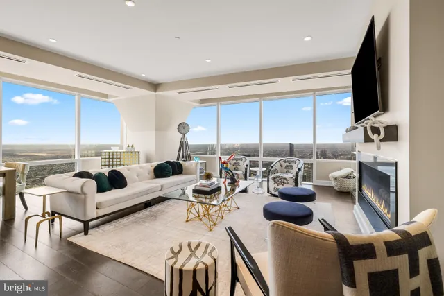 a living room with furniture kitchen view and a large window