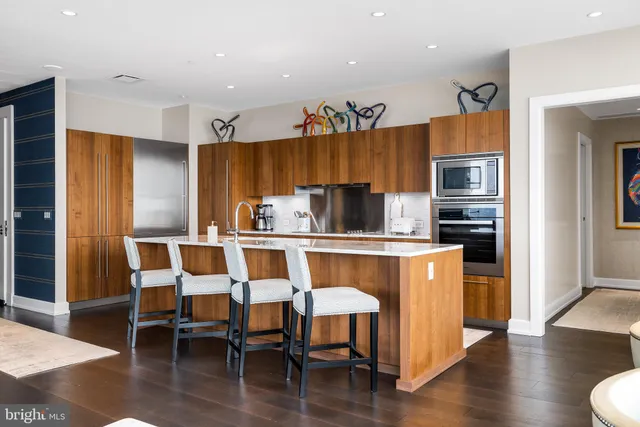 a kitchen with stainless steel appliances granite countertop a table and chairs