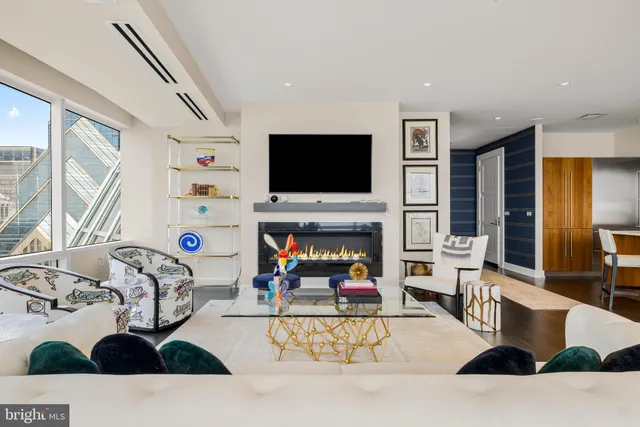 a living room with furniture a flat screen tv and a fireplace