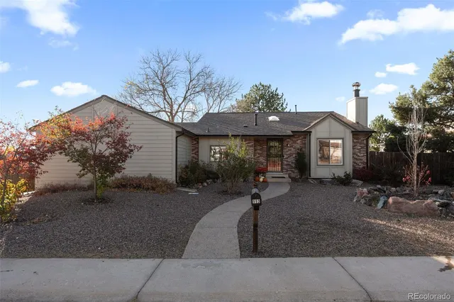 a front view of a house with garden and plants