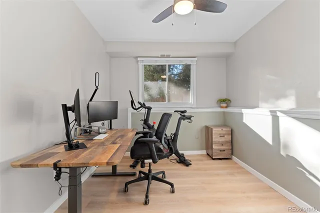 a view of a workspace with furniture and a window
