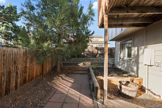 a view of a patio with table and chairs and wooden fence