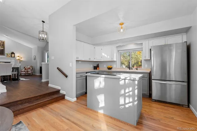 a kitchen with kitchen island wooden floors appliances and center island