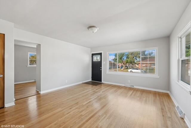 4865 Connecticut Street Gary, IN 46409 - Photo 4 of 9 an empty room with wooden floor and windows