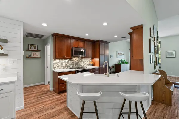 a kitchen with stainless steel appliances kitchen island granite countertop a kitchen island and a refrigerator
