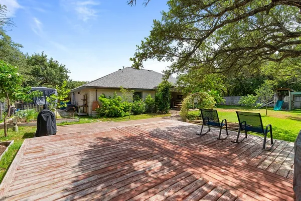 a view of a backyard with table and chairs under an umbrella