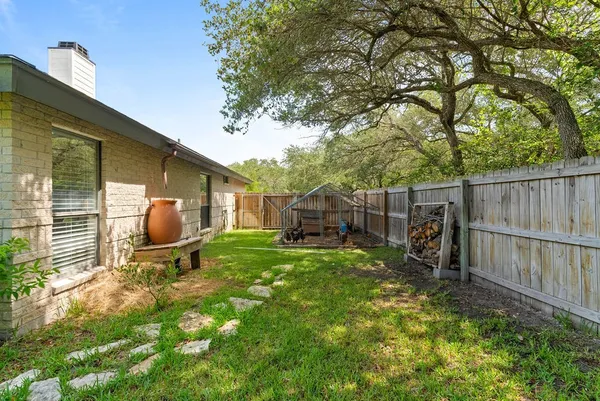a view of a chair and table in backyard of the house