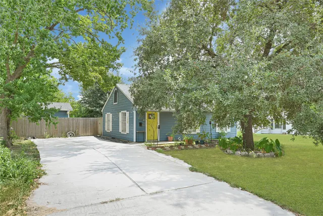 a front view of a house with a yard and trees