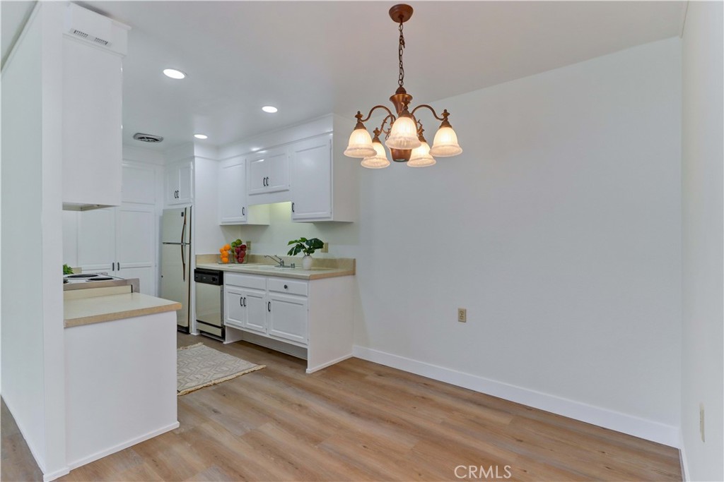 2123 Ronda Granada, Unit A Laguna Woods, CA 92637 - Photo 13 of 34 a kitchen with stainless steel appliances granite countertop a sink cabinets and wooden floor