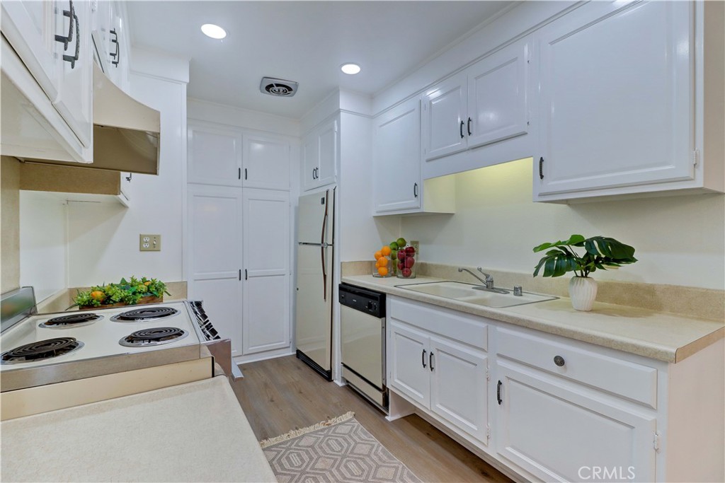 2123 Ronda Granada, Unit A Laguna Woods, CA 92637 - Photo 17 of 34 a kitchen with stainless steel appliances white cabinets and a potted plant