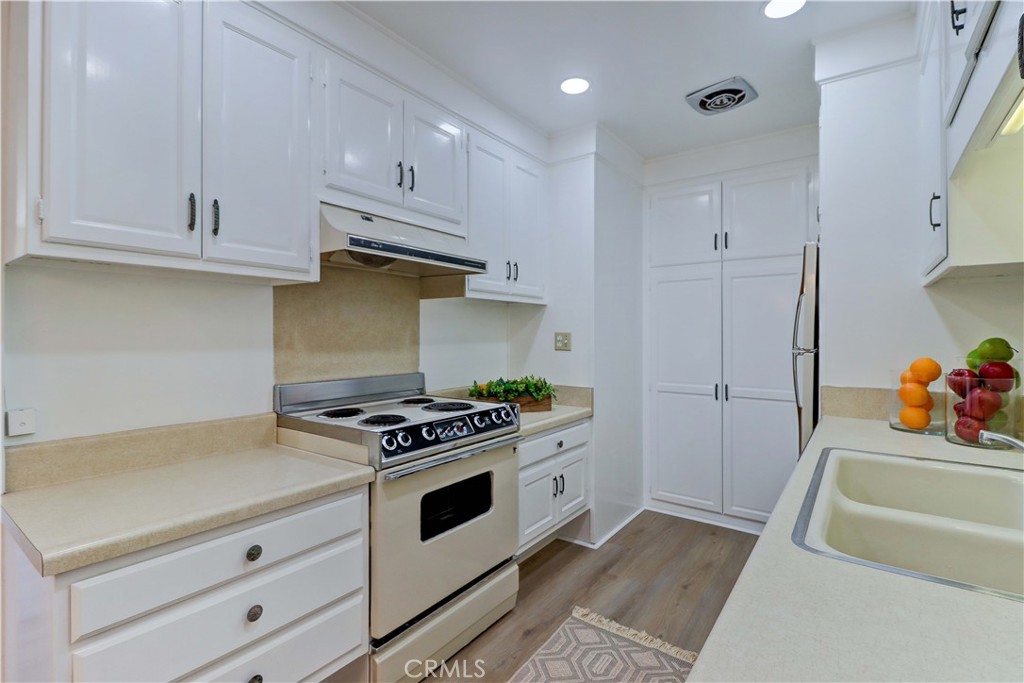 2123 Ronda Granada, Unit A Laguna Woods, CA 92637 - Photo 18 of 34 a kitchen with white cabinets and appliances