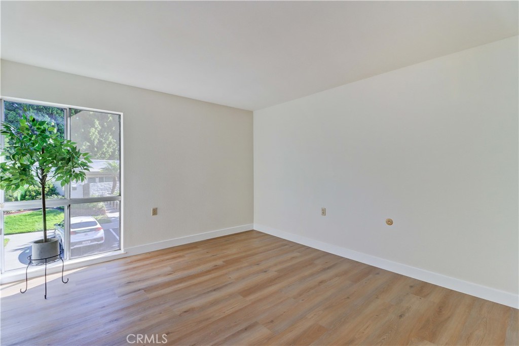 2123 Ronda Granada, Unit A Laguna Woods, CA 92637 - Photo 27 of 34 a view of an empty room with wooden floor and a window