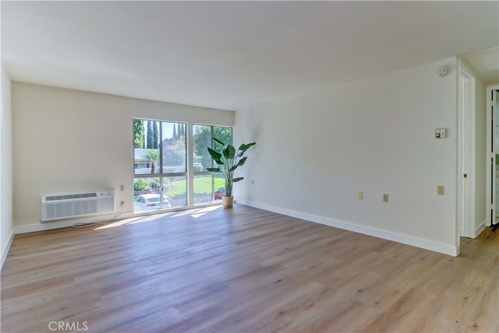 2123 Ronda Granada, Unit A Laguna Woods, CA 92637 - Photo 7 of 34 a view of an empty room with wooden floor and a window