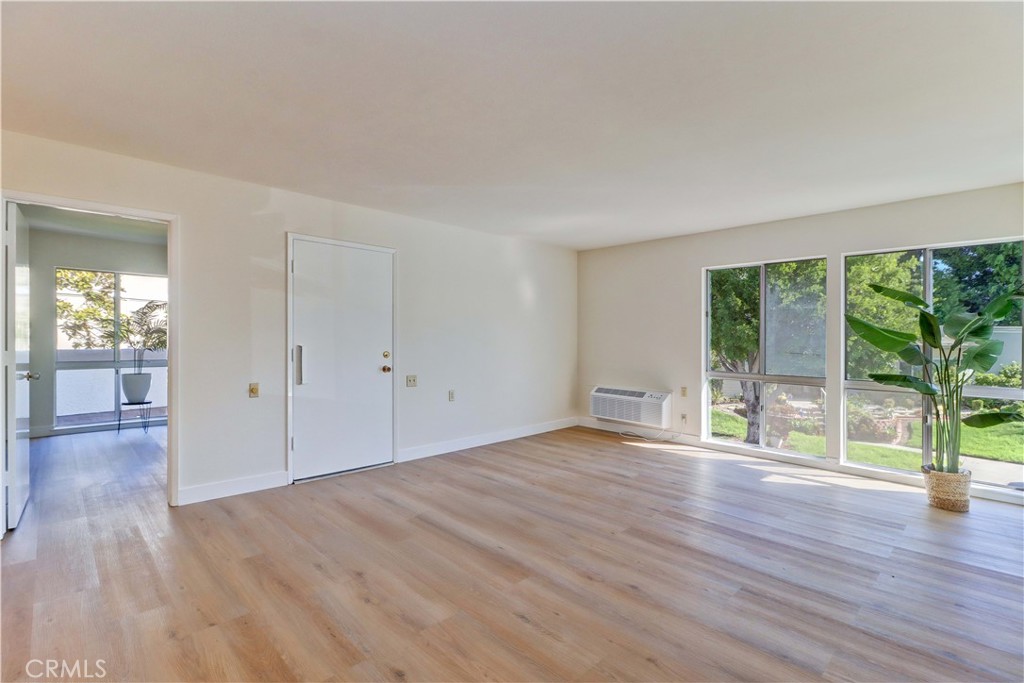 2123 Ronda Granada, Unit A Laguna Woods, CA 92637 - Photo 10 of 34 wooden floor in an empty room with a window