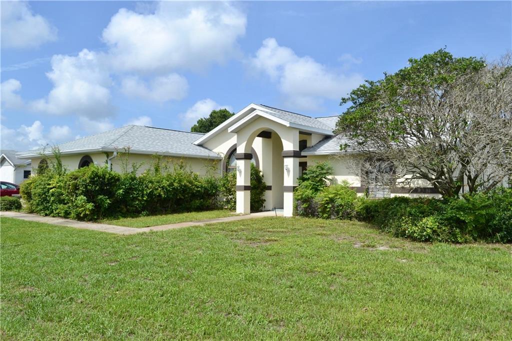 7925 Seasons Lane New Port Richey, FL 34653 - Photo 1 of 1 a front view of a house with a big yard and potted plants