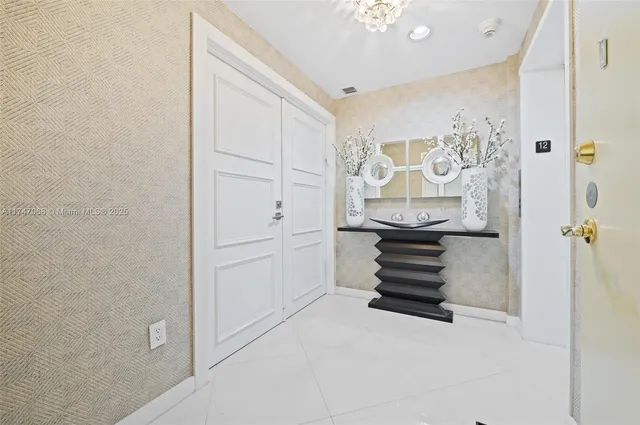 a hallway with white cabinets and stainless steel appliances