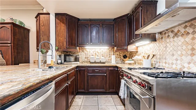 a kitchen with stainless steel appliances granite countertop a stove and a sink