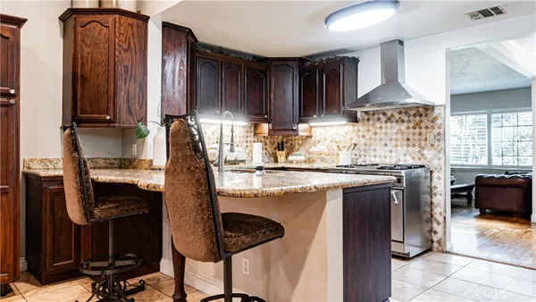 a kitchen with stainless steel appliances granite countertop a sink refrigerator and cabinets
