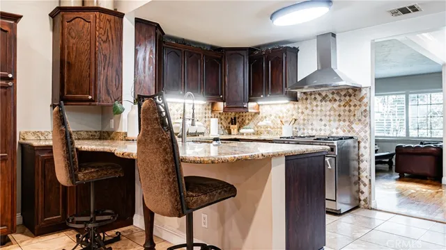 a kitchen with stainless steel appliances granite countertop a sink refrigerator and cabinets