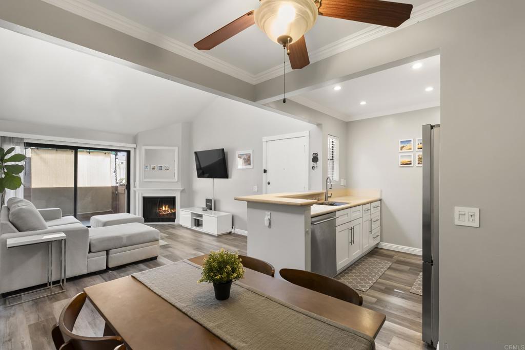 2920 Briarwood Road, Unit G11 Bonita, CA 91902 - Photo 9 of 23 a open kitchen with stainless steel appliances kitchen island granite countertop a refrigerator a sink dishwasher a dining table and chairs with wooden floor